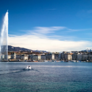 Le Jet d’eau et la rade de Genève sous un ciel bleu, avec les montagnes en arrière-plan