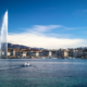Le Jet d’eau et la rade de Genève sous un ciel bleu, avec les montagnes en arrière-plan