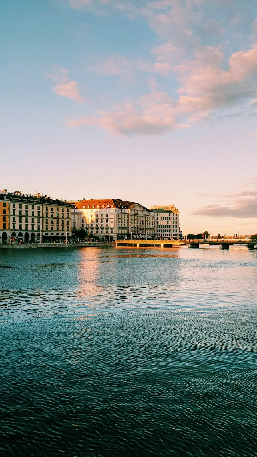 Les quais de Genève au coucher du soleil, ciel rose et eau calme